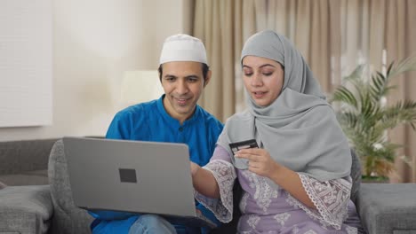 Pareja-Musulmana-Haciendo-Compras-En-Línea-En-Una-Computadora-Portátil-Usando-Tarjeta-De-Crédito