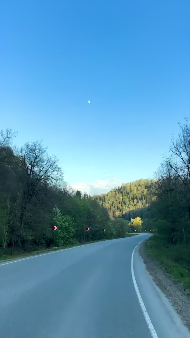 Mountain Road Under a Blue Sky with Moon