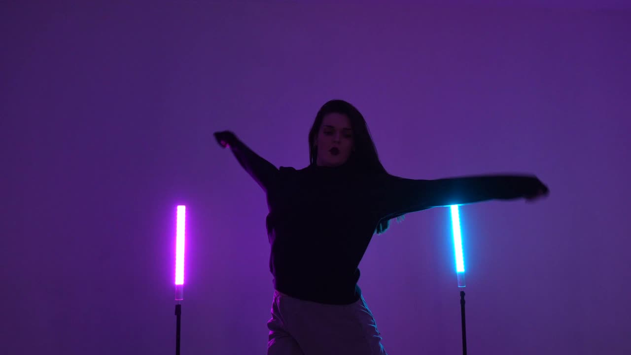 Woman Dancing in Studio with Neon Lights