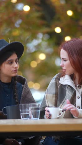 two women enjoying coffee outdoors