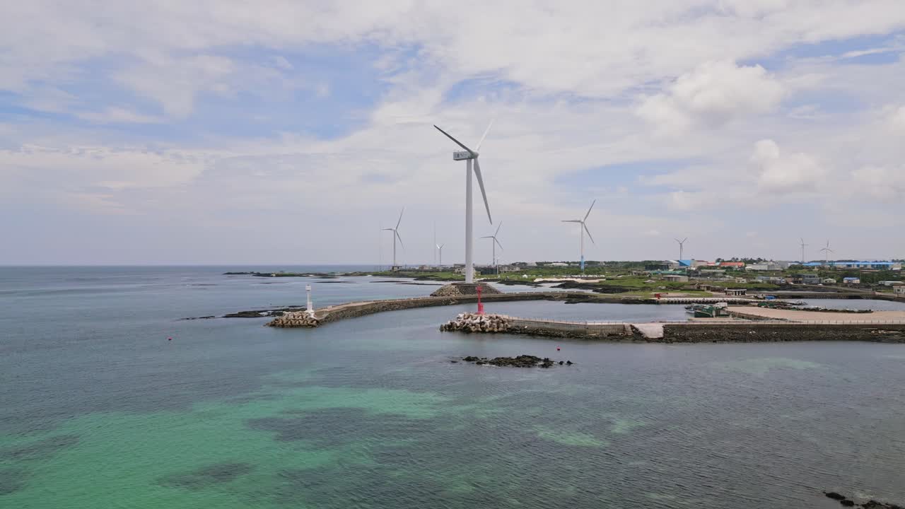 Stunning drone view of Woljeong Beach's pristine shores, a tranquil oasis on beautiful Jeju Island, with a unique view of Wind Turbines in right on the waters edge