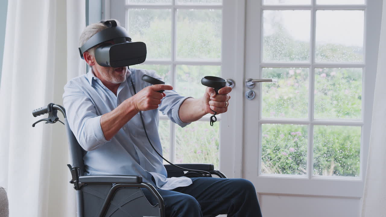 Anziano disabile in sedia a rotelle a casa che indossa un visore per la realtà virtuale e tiene in mano controller di gioco.