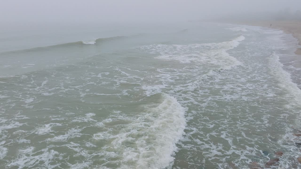 리파자 콘크리트 부두 항구, 발트해 해안선, 짙은 안개가 낀 안개 낀 날, 변덕스러운 느낌, 큰 폭풍우가 튀는 것, 넓은 드론 샷이 뒤로 낮게 움직이는 모습