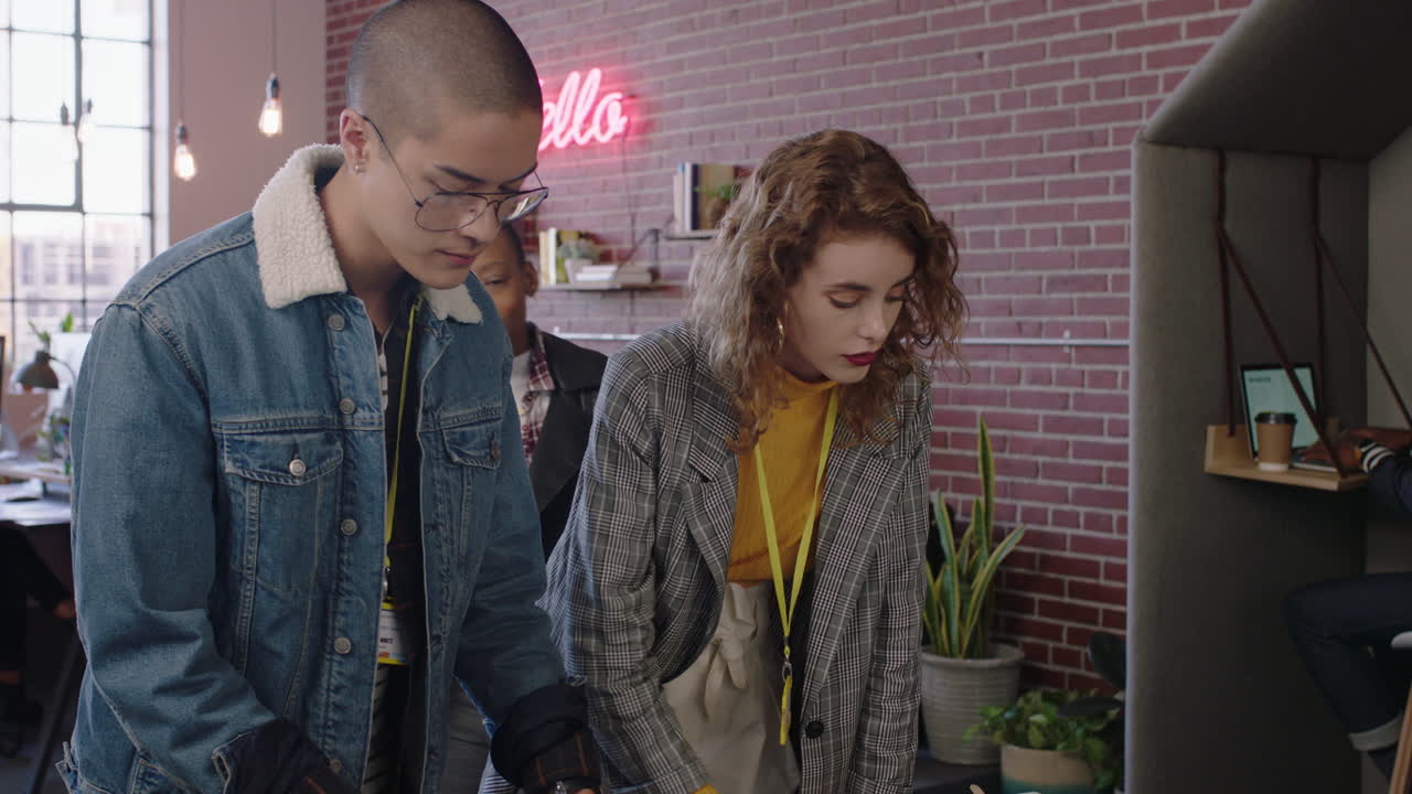 equipo de jóvenes empresarios de lluvia de ideas trabajando juntos compartiendo ideas utilizando tecnología de computadoras móviles colegas disfrutando del trabajo en equipo colaborando en el desarrollo de proyectos en un lugar de trabajo de oficina de moda