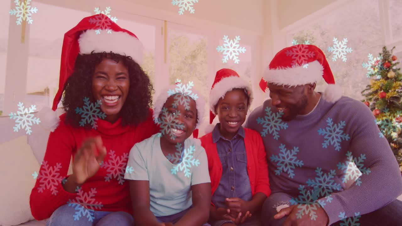 animación de la nieve cayendo sobre la familia sonriente con sombreros de santa agitando las manos