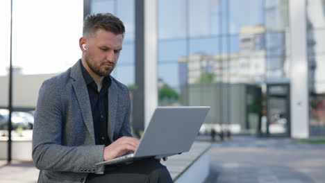 hombre de negocios trabajando en una computadora portátil al aire libre