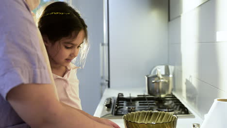 side view of mother with hiyab and daughter in the kitchen.