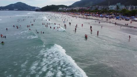 popular tropical beach in brazil full of people swimming