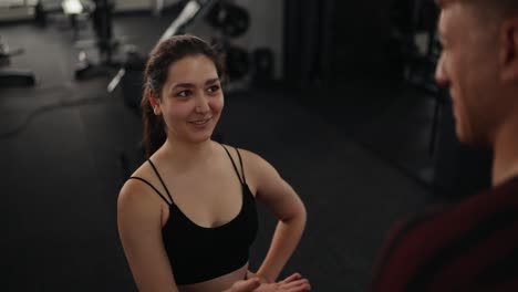 woman and her personal trainer discussing workout plan in gym