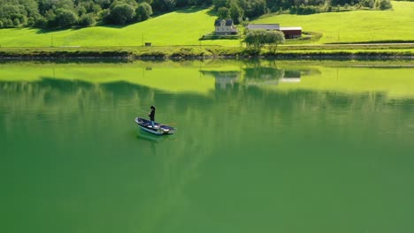 woman on the boat catches a fish on spinning in norway.