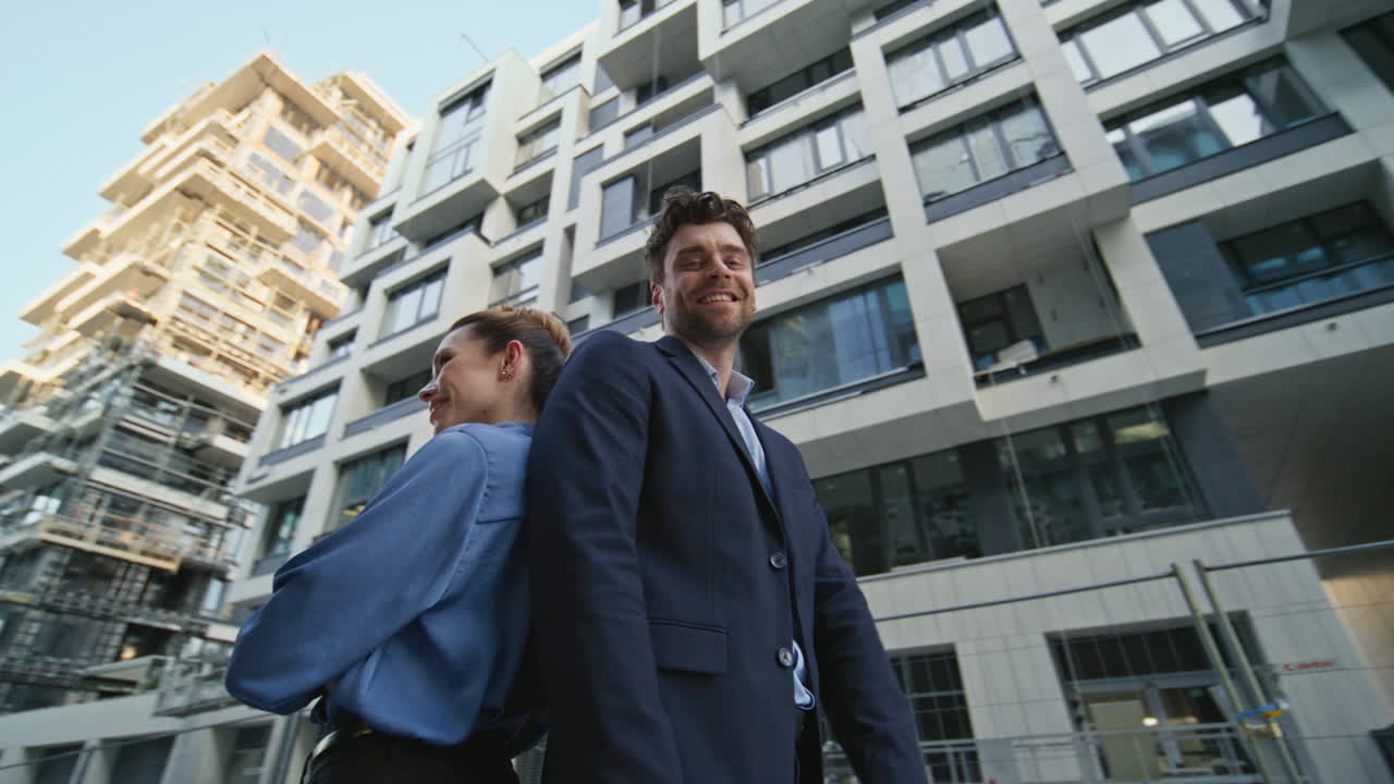 compañeros de oficina posando en la calle. alegres socios de negocios de pie de espaldas