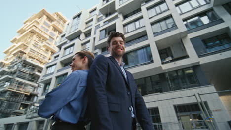 office coworkers posing street. cheerful business partners standing back to back