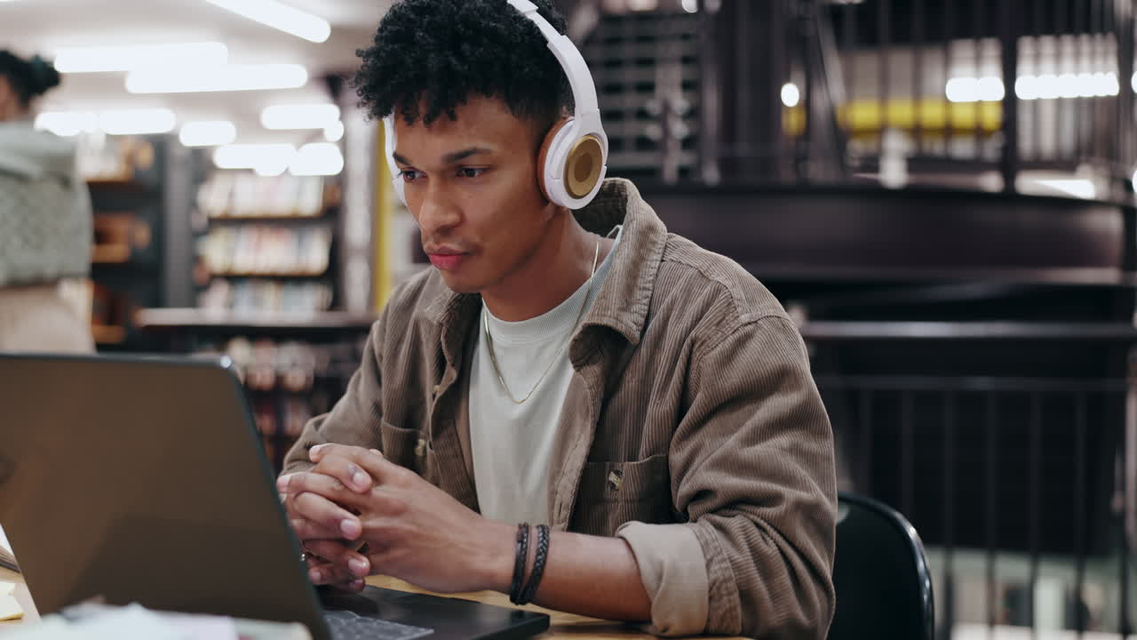 Man studying in library with headphones
