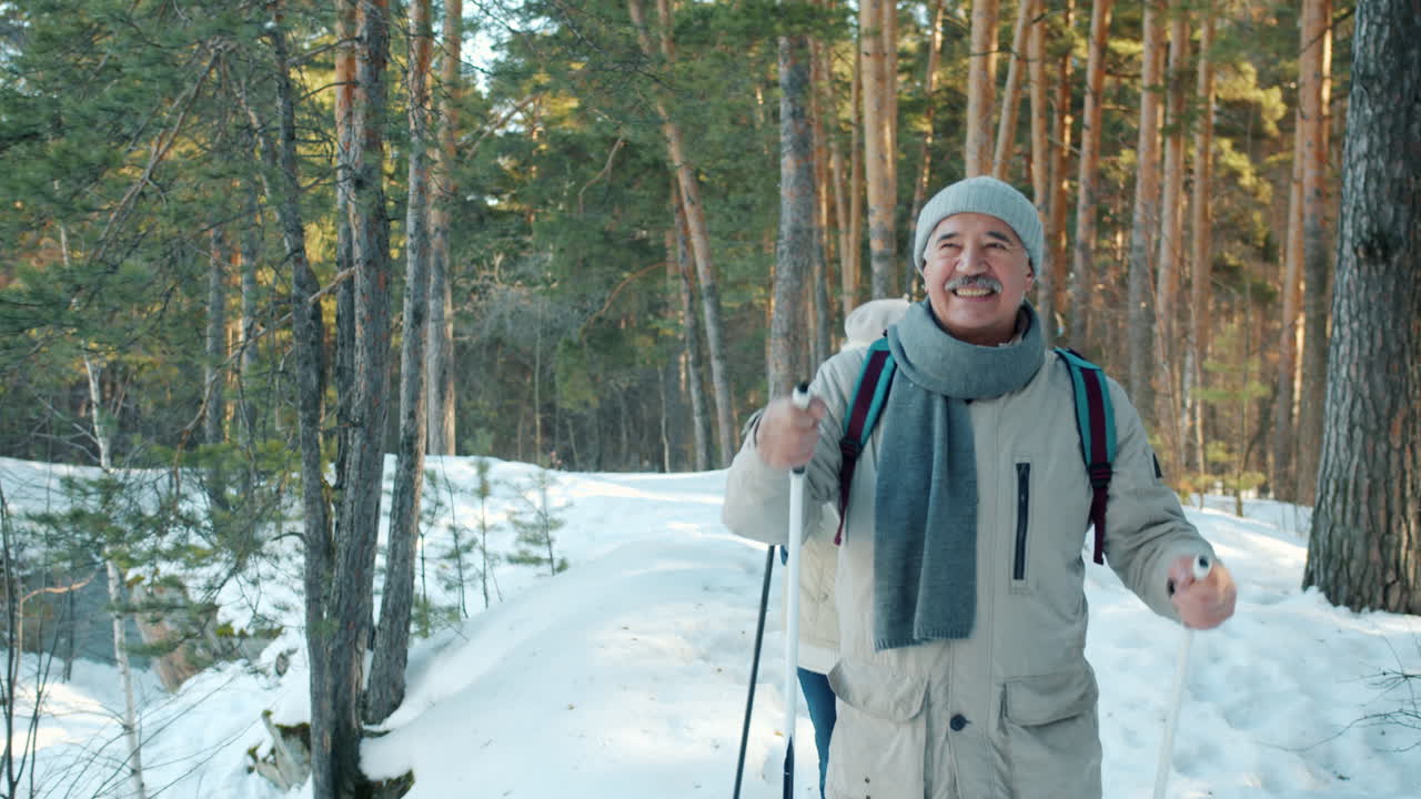Senior Couple Snowshoeing in Winter Forest