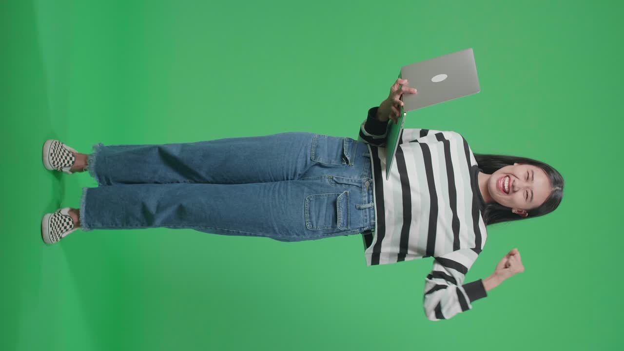 mujer celebrando con una computadora portátil