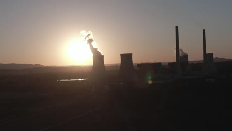 Aerial:-Drone-shot-flying-to-the-right-around-a-power-plant-station-during-sunset-in-New-South-Wales,-Australia