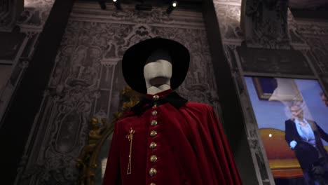 historical red cape and hat on mannequin in museum exhibition