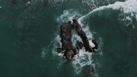 Vista-De-Arriba-Hacia-Abajo-De-Las-Olas-Rompiendo-En-Las-Rocas-En-Puerto-Escondido,-Oaxaca,-México---Disparo-De-Drones