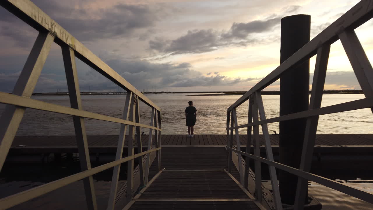 woman on a dock at sunset