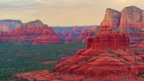 aerial push in to glowing red rock sandstone in sedona arizona at sunset, sweeping desert views