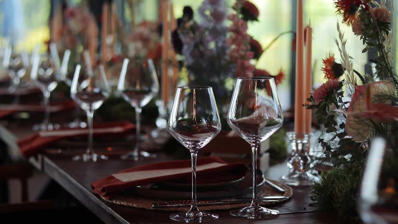 Elegant wine glasses and table setting with candles and flowers creating a festive atmosphere