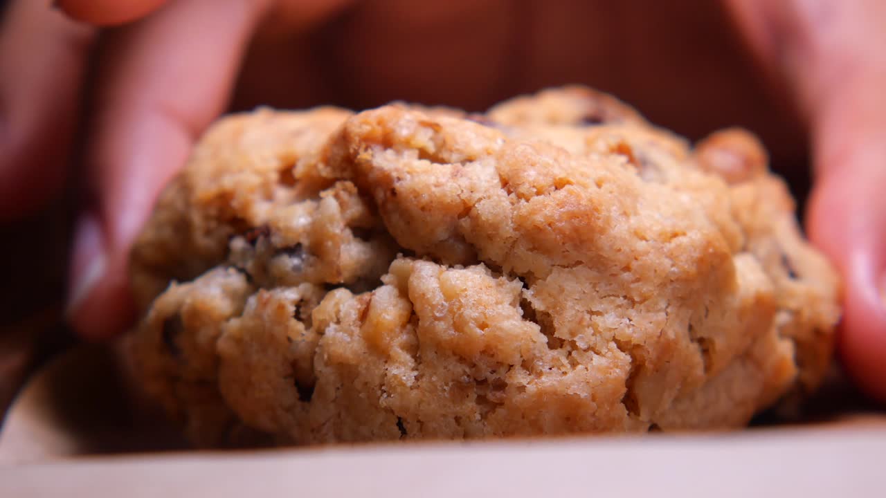 Close-up of Hands Picking Up a Freshly Baked Cookie