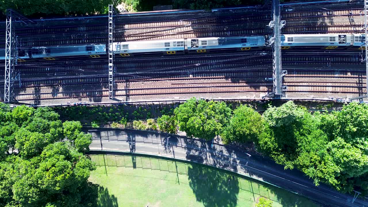Drone aerial landscape of passenger train on railway tracks line in Sydney city Central Station park Australia transport metro urban carriages CBD Surry Hills