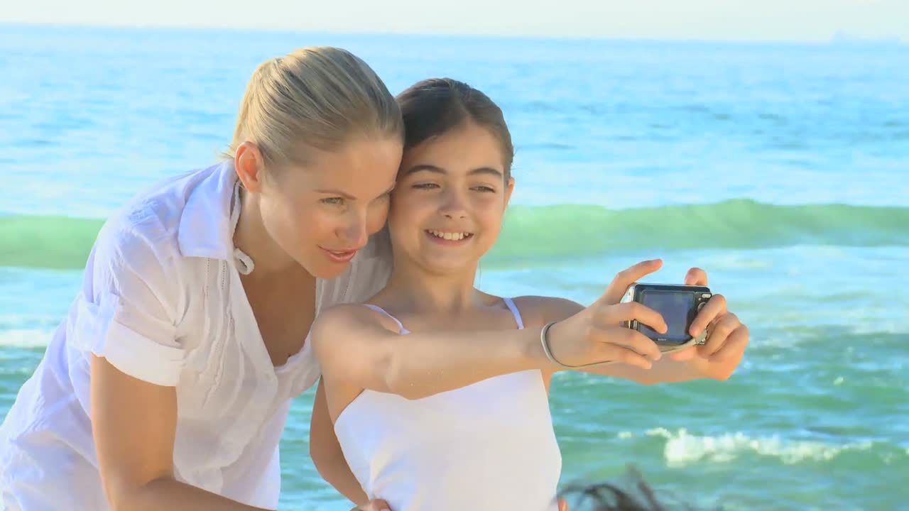 엄마와 딸과 해변에 있는 카메라