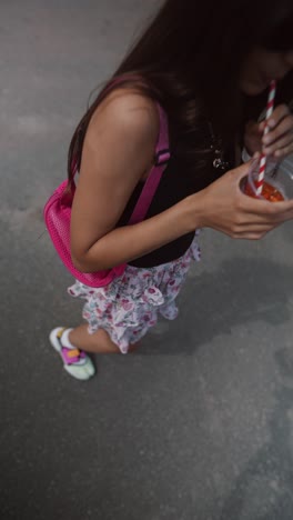 girl drinking a drink outdoors