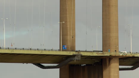 mid shot of traffic passing under the south tower of the humber bridge showing the maintenance gantry