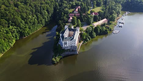 top down aerial view of orlík castle surrounded by forest and vltava river bay