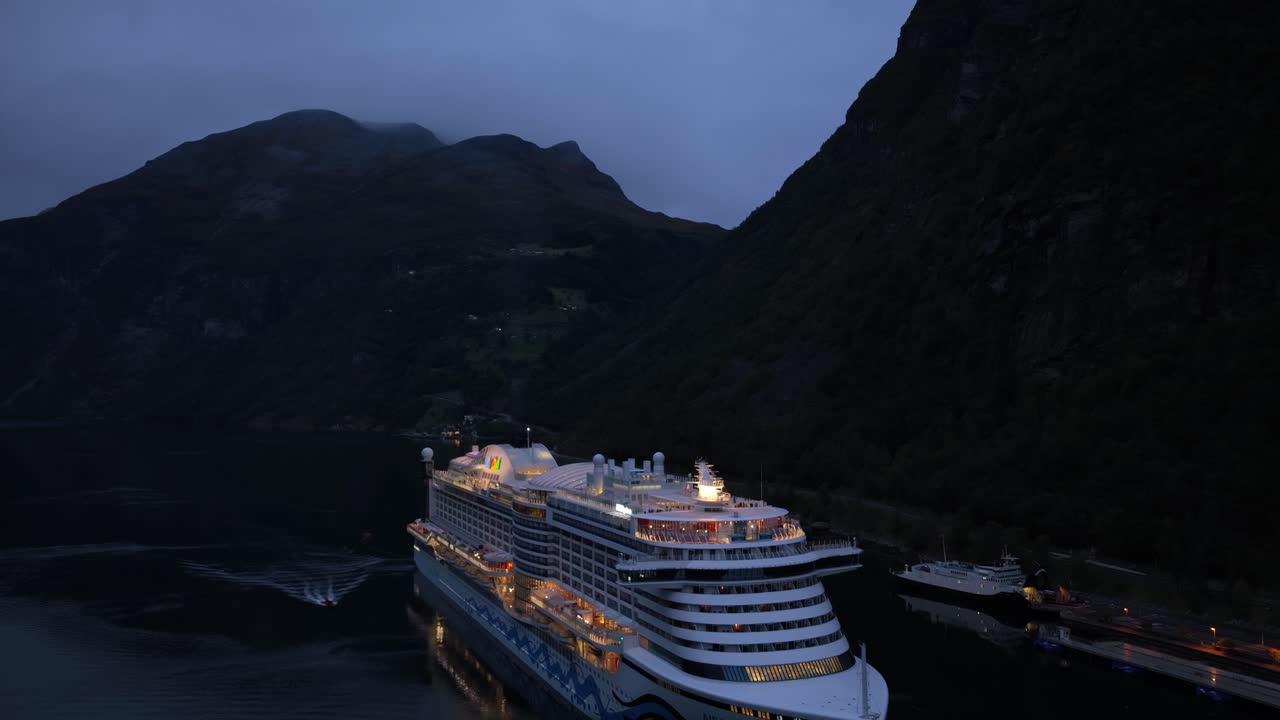 Et krydstogtskib nærmer sig Geirangerfjorden i Norge i den blå time