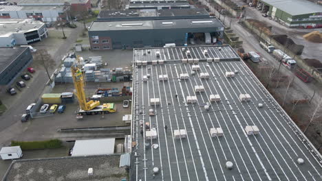 aerial of construction workers walking on rooftop on industrial site