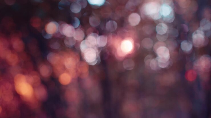 Abstract defocused forest background featuring pink and purple bokeh lights. Soft, dreamy light circles created by sunlight filtering through trees, perfect for artistic overlays