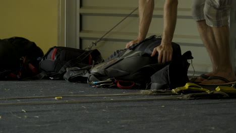 a man folds a backpack with a parachute