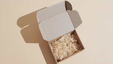 video von einer geöffneten kartonbox mit papierschnipseln und kopierraum auf braunem hintergrund