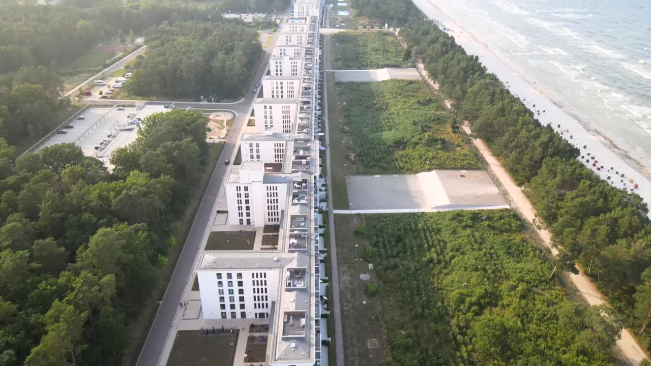 Aerial view of Prora on Rügen Island, showing the historic seaside resort stretching along the coast with the beach and Baltic Sea beside it.