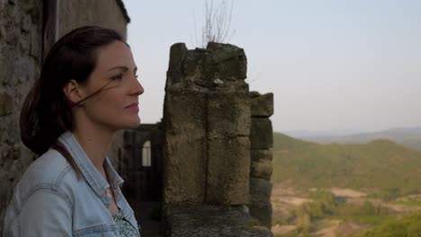 mujer mirando el paisaje desde un castillo en cámara lenta