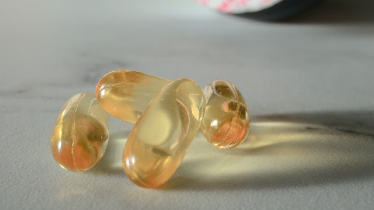 Close up of fish oil supplements scattered on a white table