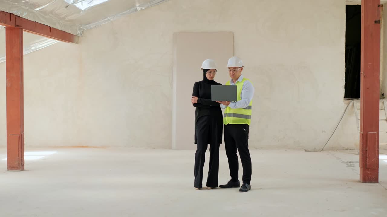 dos profesionales multinacionales diversos. un ingeniero de la industria asiática con un uniforme de seguridad mostrando el proyecto en una computadora portátil hablando con un inversor árabe musulmán. discutiendo un acuerdo de inversión.