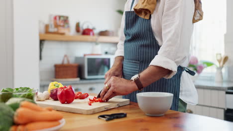 senior man chopping vegetables in kitchen