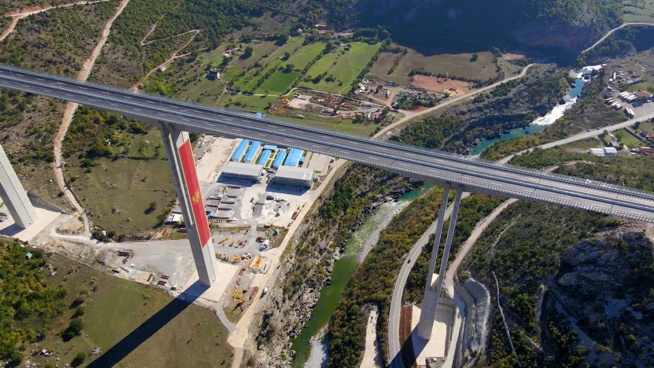 fotografía aérea del puente moracica completamente terminado en montenegro. el gran escudo de armas rojo de montenegro se ve en uno de los pilares del puente