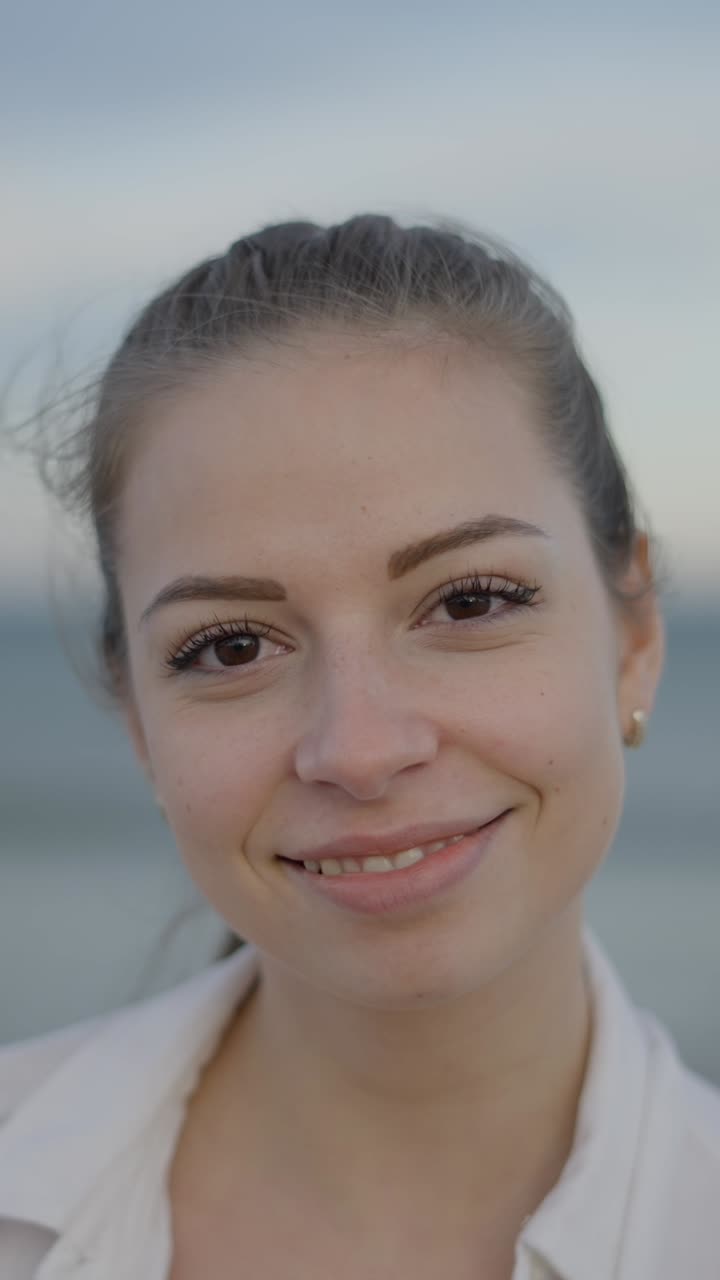 Close-up portrait of a smiling young woman outdoors