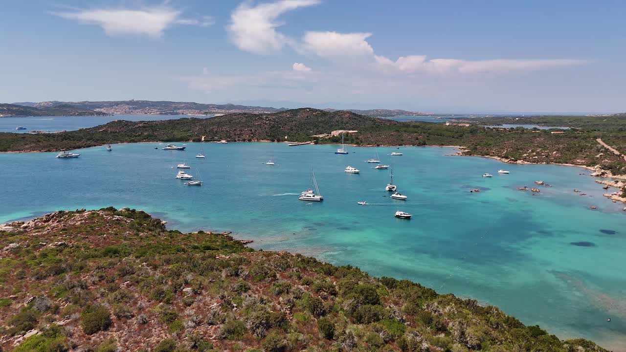 Yachts on a turquoise lagoon in Sardinia under sunny skies. Calm and serene