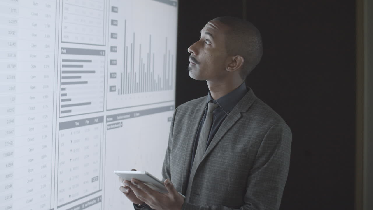 Confident black finance expert analyzing trading charts