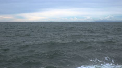 revealing shot of concrete wall only to discover a wide open ocean when the camera becomes high enough