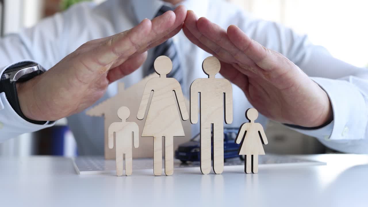 Uomo d'affari che protegge figure in legno di famiglia e bambini