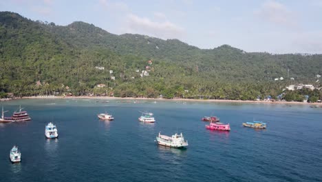 aerial view over moored boats in gulf of thailand with push forward shot towards sairee beach