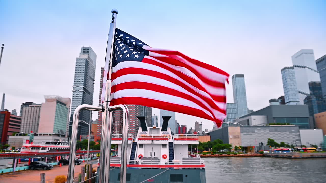Bandiera americana che sventola al vento sulla barca. Vista dal basso degli edifici di New York sullo sfondo.