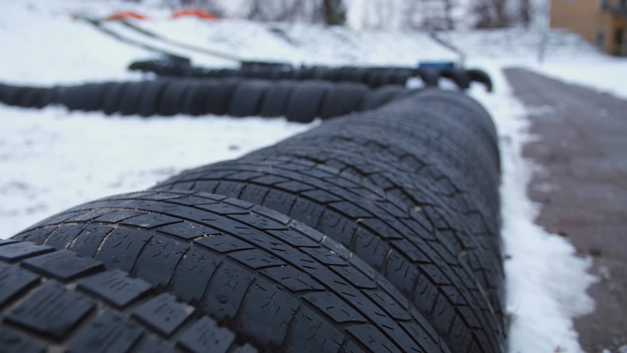 valla de barrera alrededor del patio de recreo o campo de juego hecha de neumáticos de automóviles negros enterrados en el suelo